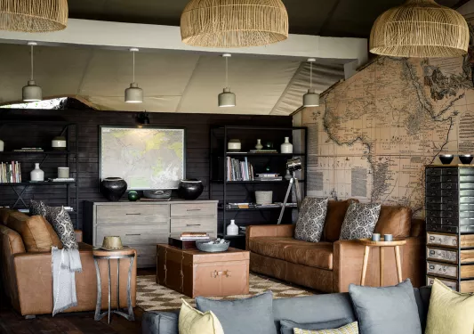 living room with leather couches, map wallpaper, and Raffa chandlier