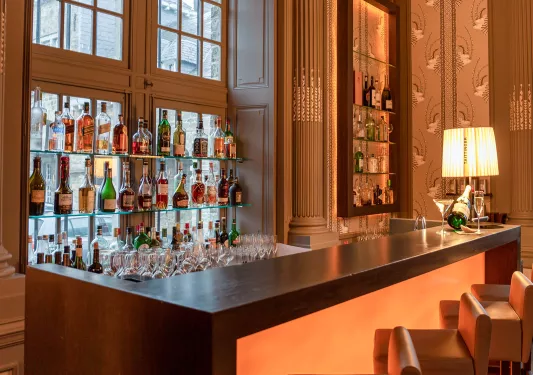 Bar with alcohol bottles on glass shelves