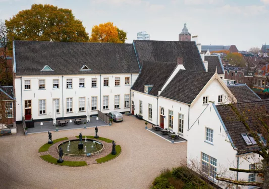 White building with an outdoor courtyard and a fountain