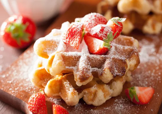 Two waffles stacked on top of each other with strawberries