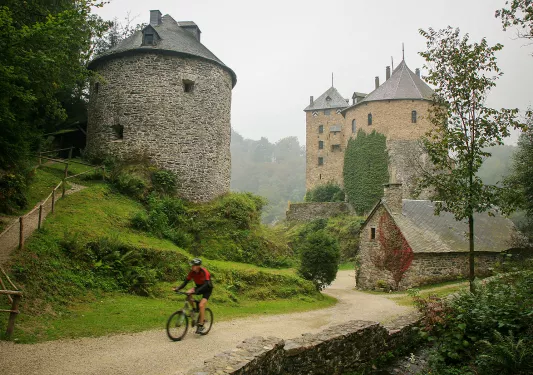 Stone towers and a man biking through the gravel trail