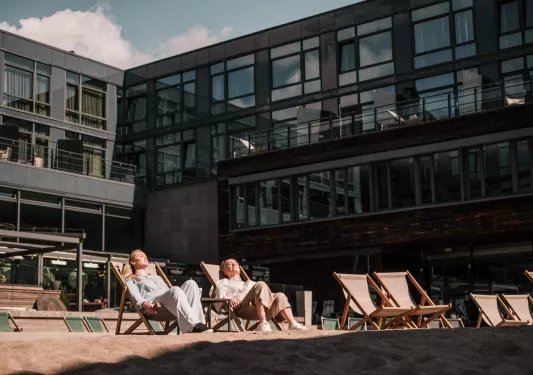 guests lounge in the sun outside the hotel