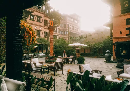 Outdoor courtyard with a waiter cleaning outdoor tables