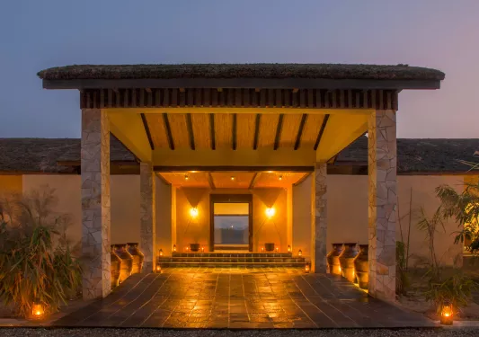 Stone building entrance, with a long path of stone and stone pillars