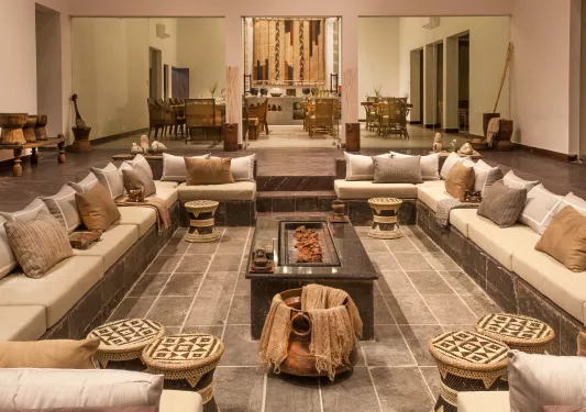 Indoor lounge with a large, square shaped seating area with cushioned sofas