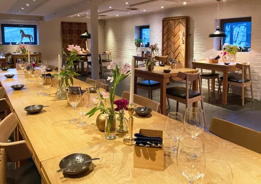 Long dining table with wine glasses and vases with flowers on top