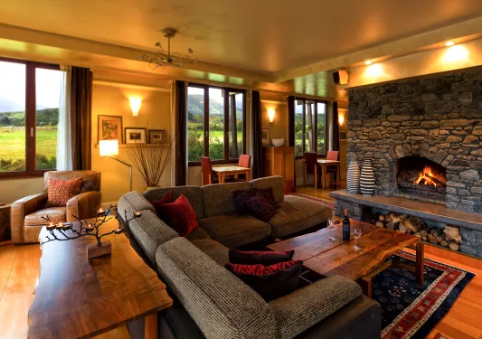 Indoor lounge area with a stone fireplace and woven cushioned seats
