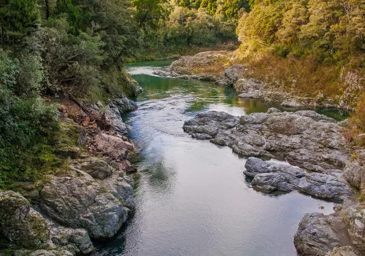 A river cutting through two small cliffs