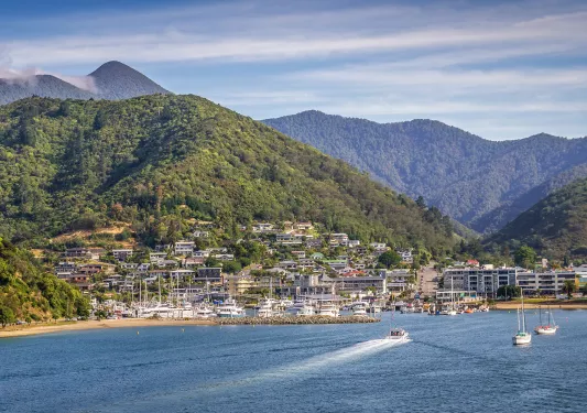Small town next to a port with boats docked along the sand