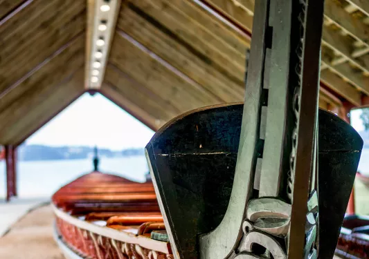 Narrow red and black boat leaving on a metal post