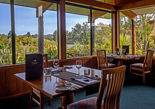 Dining room with wooden chairs and tables, and a menu on the table
