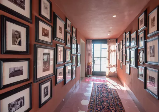 Hallway with a patterned rug and portraits on the wall