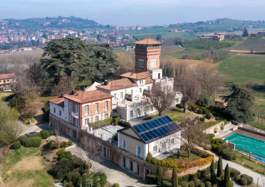 Exterior sky view of stone and brick buildings with an outdoor pool