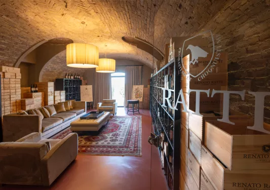 Stone cellar with cushioned seats and shelves full of wine