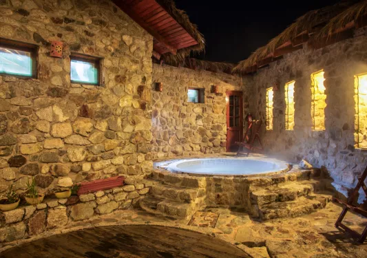 Stone room with an open hot tub in the back right