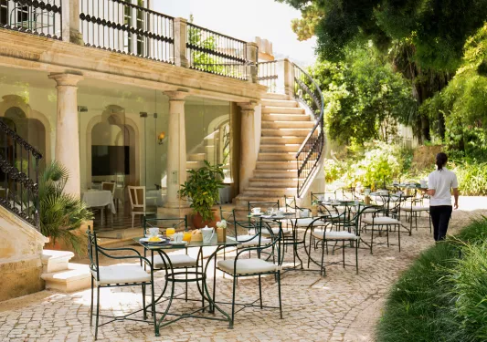 outdoor bistro tables next to a spiral staircase