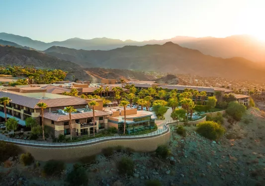 Outdoor view of hotel on a cliff, with palm trees