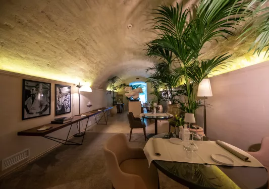 Hallway with dining tables and portraits on the walls