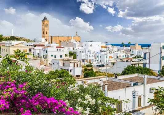 White buildings in the distance with an orange brick church building in the distance