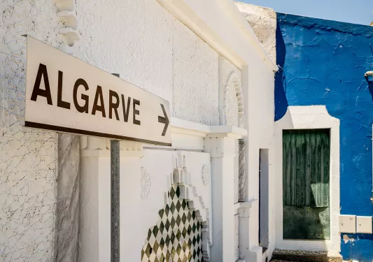 A sign pointing to a blue building with the word "Algarve"