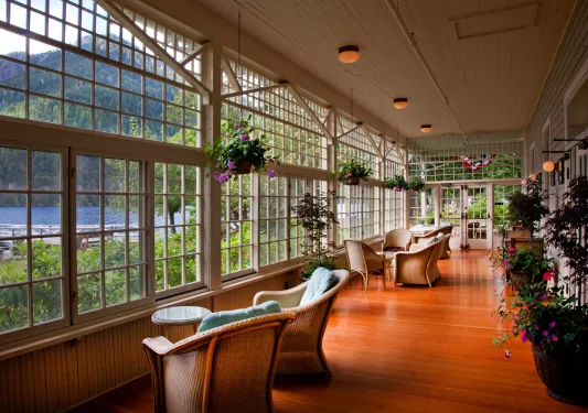 Woven chairs looking out towards the lake, surrounded by flowers