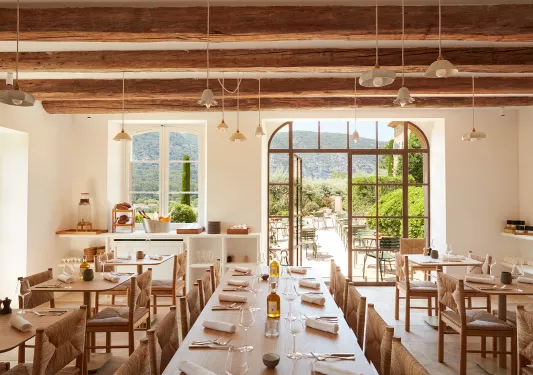 Indoor dining area with wine glasses on the tables, with a door leading to an outdoor patio