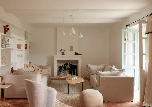 Indoor lounge with cushioned chairs with an open door on the right