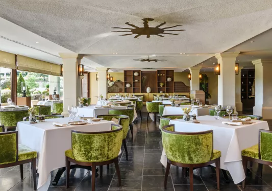 Indoor dining hall with velvet green cushioned chairs
