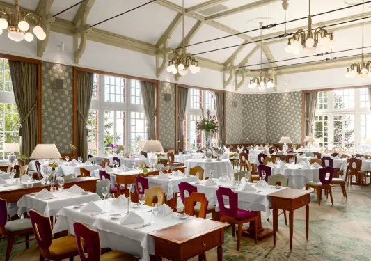 hotel restaurant with green curtains and chandeliers