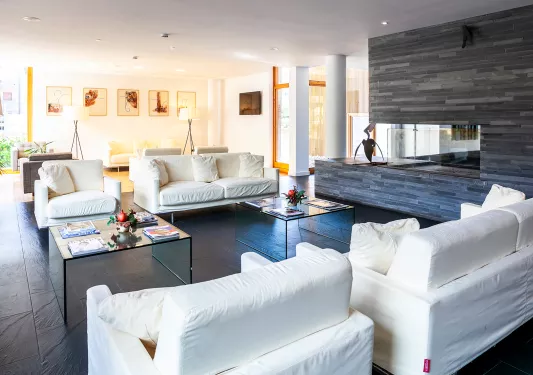 Indoor seating area with white, sofas and black stone flooring