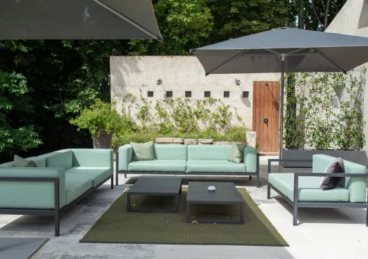 Outdoor patio with blue couches and gray umbrellas