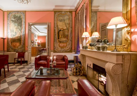 Indoor foyer with red, cushioned chairs next to a fireplace