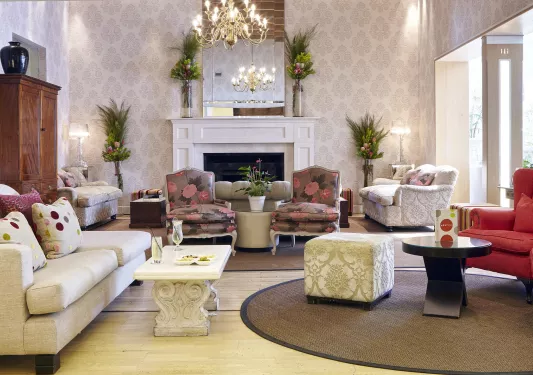 White lobby room, with flower patterned pillows and cushioned chairs