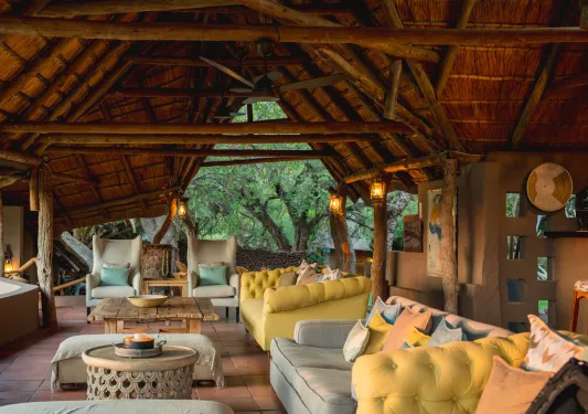 Open air lounge under a wooden hut-style roof