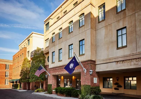 Exterior view of yellow and orange building with two flags in front