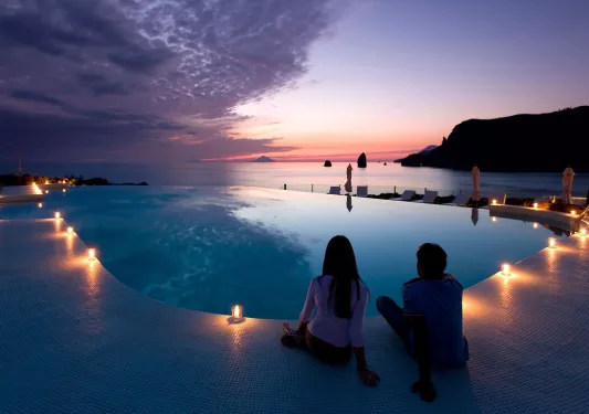 candlelit hotel pool overlooking sunset