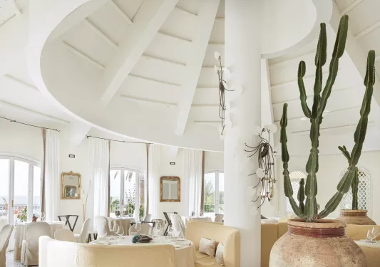 Dome-shaped room with a white pillar and chairs around each table
