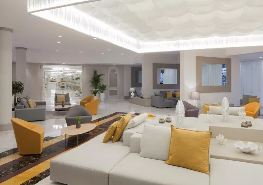 Indoor hotel lobby with a white cushioned couch in the center