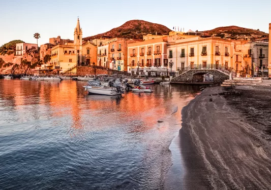 Port filled with multiple boats during sunset time