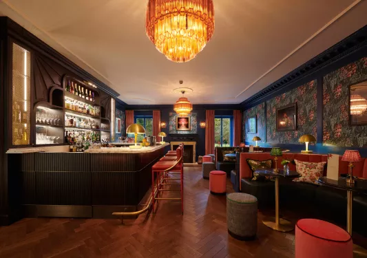 dark hotel bar with large chandelier