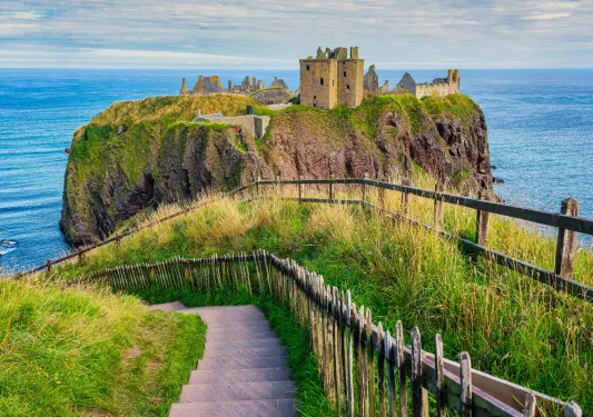 Rustic castle ruins on a cliff in the middle of an ocean