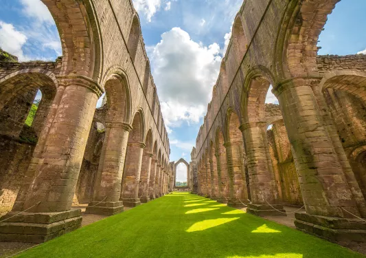 grassy path through stone archways