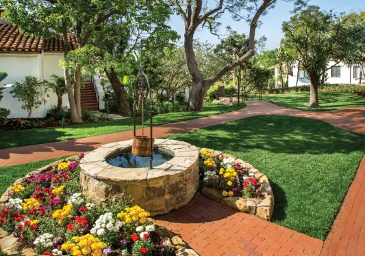Outdoor garden with a water well and brick walkways