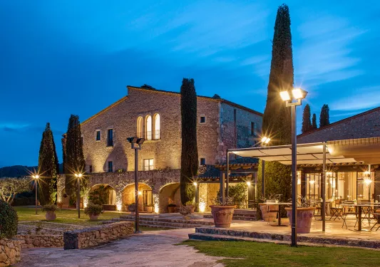 Exterior of hotel Mas Torrent lit up at night