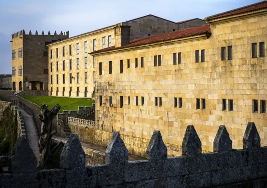 large stone buildings surrounded by hedges