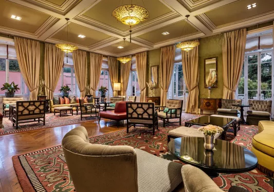 Lobby with large, tan curtains and cushioned chairs throughout the room
