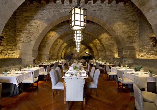 Indoor dining hall with white cushioned chairs and wooden furniture