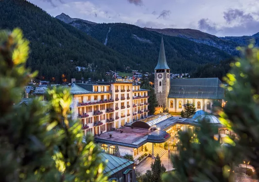 Hotel with clocktower in front of mountains