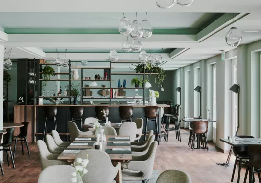Dining area and bar with light green walls and gray chairs