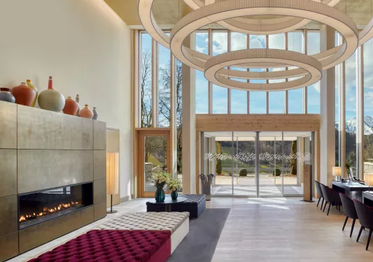 Indoor lobby with a stone fireplace and cushioned sofas in the center